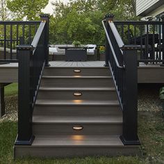 the stairs lead up to an outdoor deck with lights on each handrail and below them