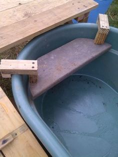 a wooden block sticking out of the side of a blue tub