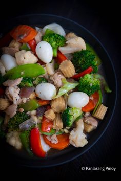 a bowl filled with vegetables and meat on top of a table