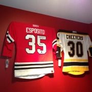 two jerseys are hanging on the wall next to each other in a room with red walls