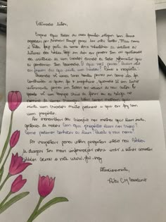 a piece of paper with writing on it and pink flowers in the bottom left corner