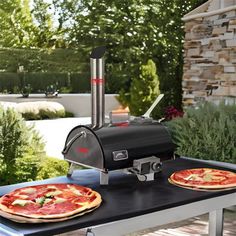 two pizzas sitting on top of an outdoor grill