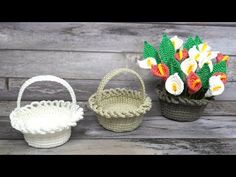 three crocheted baskets with flowers in them