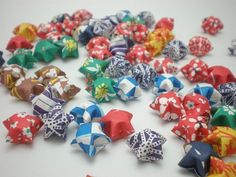 many different colored bows are laying on the table together and scattered around each other, including one with an origami star