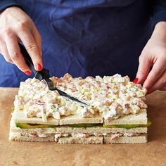 a person cutting up a sandwich with a knife