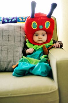 a baby in a bug costume sitting on a couch