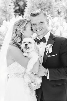 the bride and groom are hugging their dog