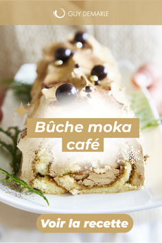 a person holding a white plate with food on it and the words buche moka cafe