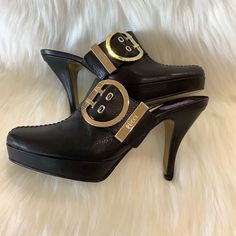 Emilio Pucci Black Leather Slip-On Heeled Clogs In A Size 37 (Us 61/2). They Are Italian Sizing. Semi Pointed-Toe Clogs With Platforms, Tonal Stitching And Buckle Accent At Uppers With The Pucci Logo. These Are Beautiful Shoes And Are In Excellent Preowned Condition, The Only Ware Is On The Soles!!! Size: Eur 37/ Us 61/2 Heel Height: 3.75" Platforms: 0.75" Tapers To 1”. Toe Type: Almond Toe Color: Black Features: Adjustable, Buckle Made In Italy Smooth Leather Clog Style With Open Heel Design Go Luxury Mules With 4-inch Almond Toe, Designer Mules With Buckle Closure And Open Heel, Luxury Closed Toe Mules With 4-inch Heel, Designer Leather Mules With Buckle Closure, Luxury Black Mules With Buckle Closure, Luxury 4-inch Heel Closed Toe Mules, Elegant Black Almond Toe Clogs, Designer Round Toe Mules With Buckle Closure, Designer High Heel Mules With Buckle Closure