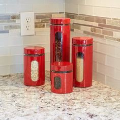 three red canisters sitting on top of a counter