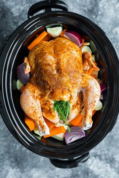 a whole chicken in a crock pot with carrots, onions and celery