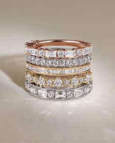 a stack of different colored gold and silver rings with diamonds on them, all stacked together