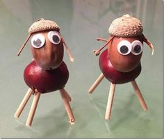 two apples with googly eyes and sticks sticking out of their heads, sitting on top of each other