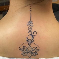 the back of a woman's neck with a lotus tattoo on it