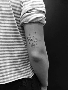 a person with a tattoo on their arm and the moon in the sky above them