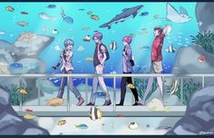 several people standing on a bridge looking at fish in an aquarium with sharks and other sea creatures