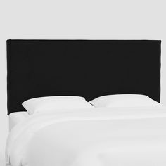 a black headboard with white sheets and pillows