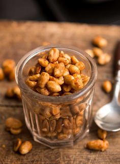 nuts are in a glass container on a wooden table