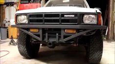 the front end of a white truck parked in a garage