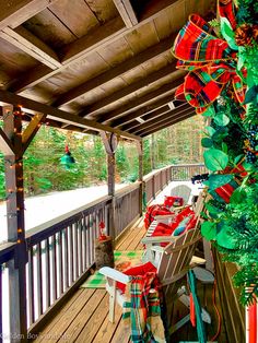 an outdoor covered deck with chairs and christmas decorations on the table, along with lights hanging from the ceiling