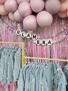 there are many balloons and clothes hanging on the rack