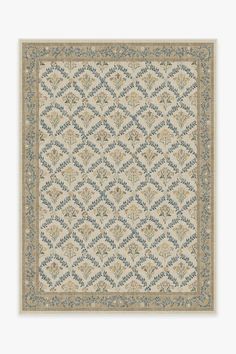 a beige and blue rug with an intricate design on the bottom, in front of a white background