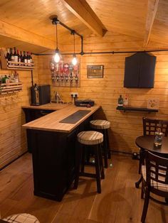 a small bar with stools in a wood paneled room