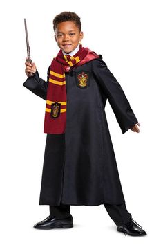 a young boy dressed in harry potter costume holding a wand and wearing a black robe