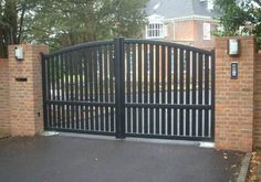 an iron gate with brick pillars and gates