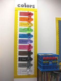 a colorful bulletin board with the words colors on it next to a stack of books