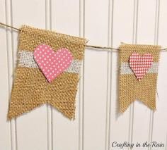 burlap banner with two hearts hanging from it's sides on a white wall