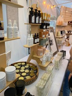 a woman standing in front of a counter filled with cosmetics