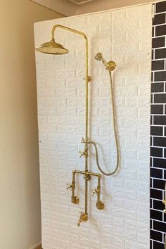 a shower head and hand held shower faucet in a bathroom with white brick walls