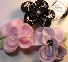 three flower hair clips with skulls and bones on them sitting next to a bottle opener