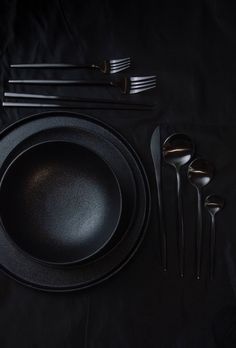 a black table setting with silverware and utensils