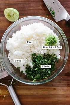 the ingredients for rice are in a glass bowl next to a knife and lime wedges