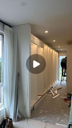 a man is standing on a ladder in the middle of a room that's being remodeled