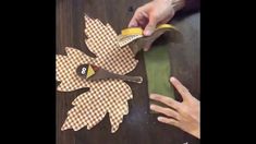 someone is cutting out some paper leaves with scissors