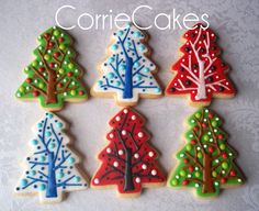 decorated cookies in the shape of christmas trees on a white tablecloth with words cookie cakes