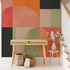 a table and two stools in front of a wall with an abstract design on it