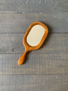 a wooden mirror sitting on top of a wooden floor