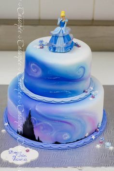 a three tiered cake decorated with an image of princess aurora and the snow queen