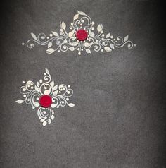 two red and white designs are on the floor in front of a black background with silver accents