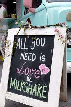 a chalkboard sign that says all you need is love and milkshake