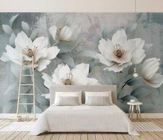 a bed sitting under a large white flower wall mural