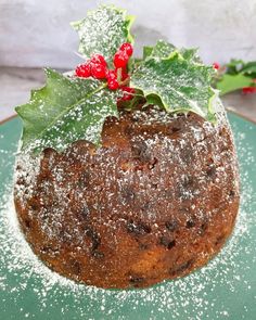 A closeup of a steamed fig pudding, with holly leaves and flowers perched on top for decoration, plus a dusting of powdered sugar . Christmas Pudding Photography, Figgy Pudding Recipe, Traditional Christmas Pudding, Twigg Studios, Hard Sauce, Favorite Christmas Desserts, Christmas Pudding Recipes, English Desserts, Candied Lemon Peel