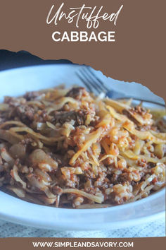 a white plate topped with pasta and meat next to a fork on top of a table