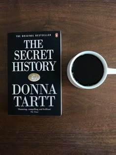 the secret history by donna tarti next to a cup of coffee