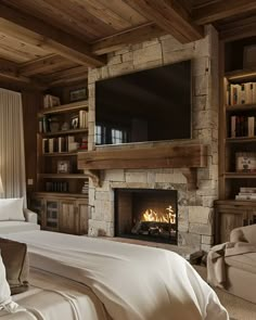 a bedroom with a bed, fireplace and television in it's centerpieces