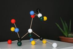 the model is made up of different colored balls and wooden dows on a white table